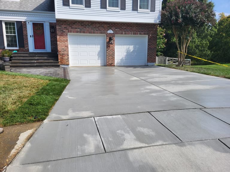 The driveway and widened apron with the red front door beyond