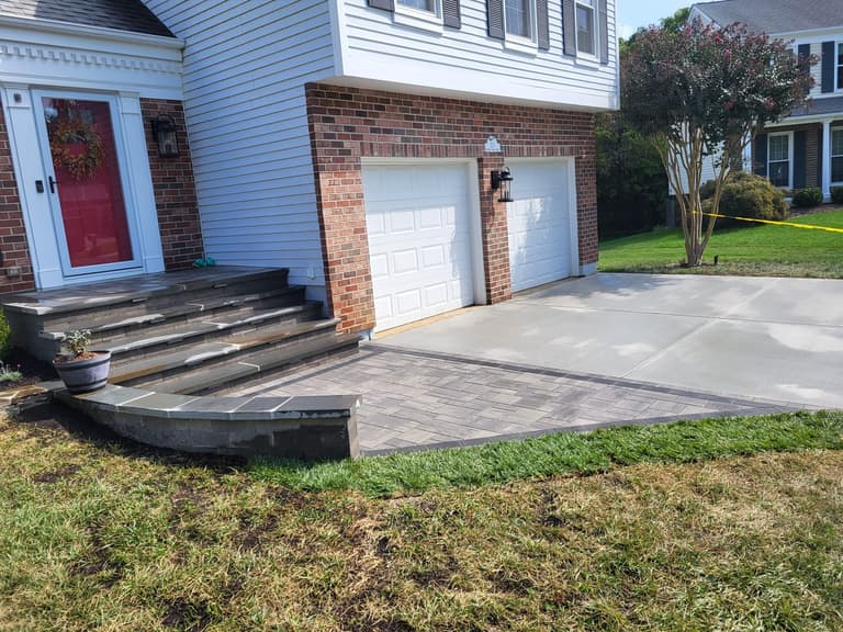The rebuilt driveway running past the charcoal paver landing and steps