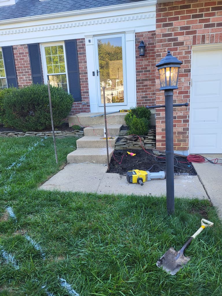 Demolition — the front bed stripped out and the breaker staged against the original concrete steps