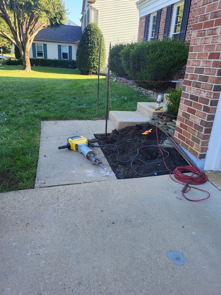 Demolition — hoses and marking flags run out across the old walk before the concrete came up