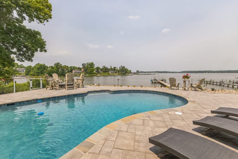 Adirondack chairs at the water's edge beyond the pool deck