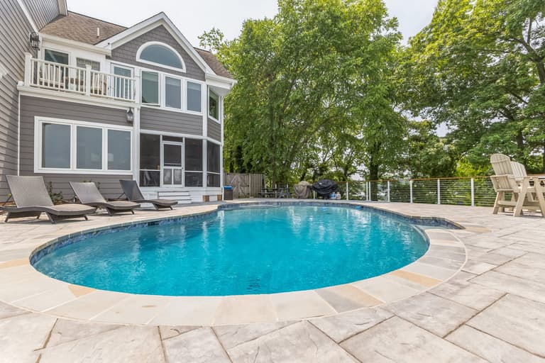 The pool between the house and the waterfront, seen along the length of the deck