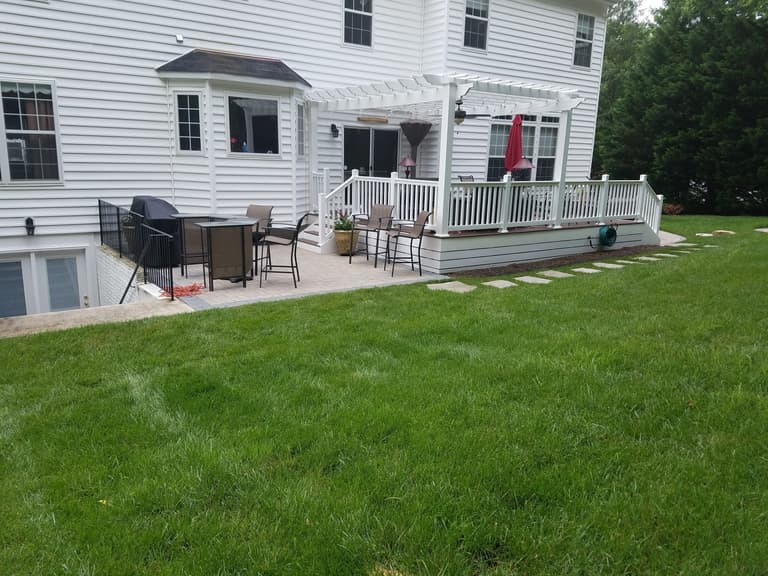 Finished paver patio with a pergola and outdoor seating