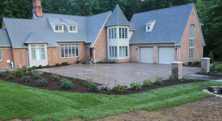 Large paver auto court and entry approach at a brick colonial home in Davidsonville