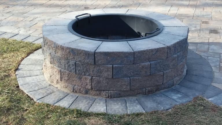 Stacked-stone fire pit on a flagstone patio