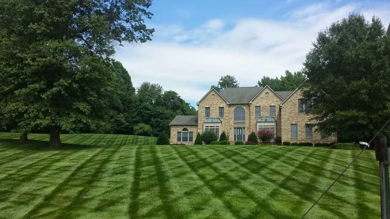 Wide striped front lawn and maintained plantings at a Davidsonville home