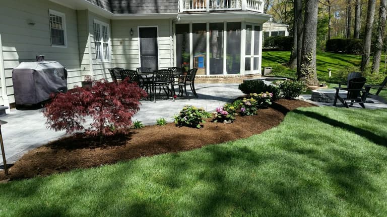 Freshly mulched planting beds and a manicured lawn after a property cleanup