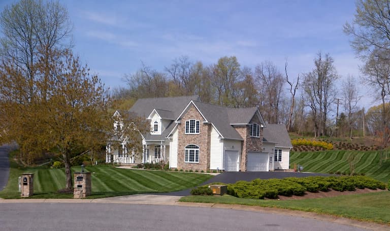 Maintained lawn, mulched beds, and evergreen plantings at a Lothian property