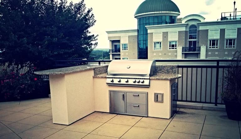 Rooftop terrace grill island with a granite counter and built-in storage