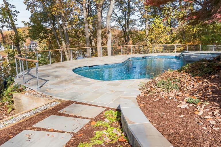 Flagstone pool deck with steps down to a freeform pool