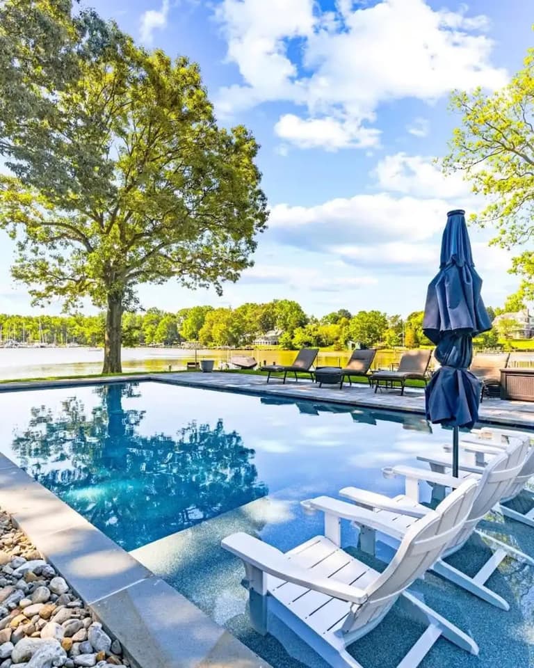 Rectangular pool and paver deck overlooking a lake