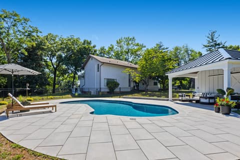 Freeform pool and pavilion with the home beyond