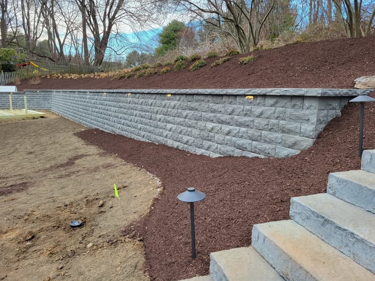 Tiered segmental retaining wall with integrated steps and path lighting
