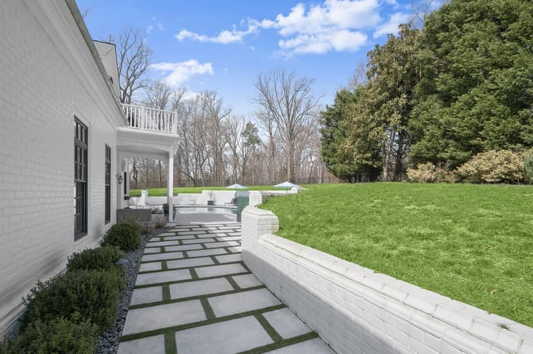 Sandblasted marble walkway with turf inlays wrapping the side of the home