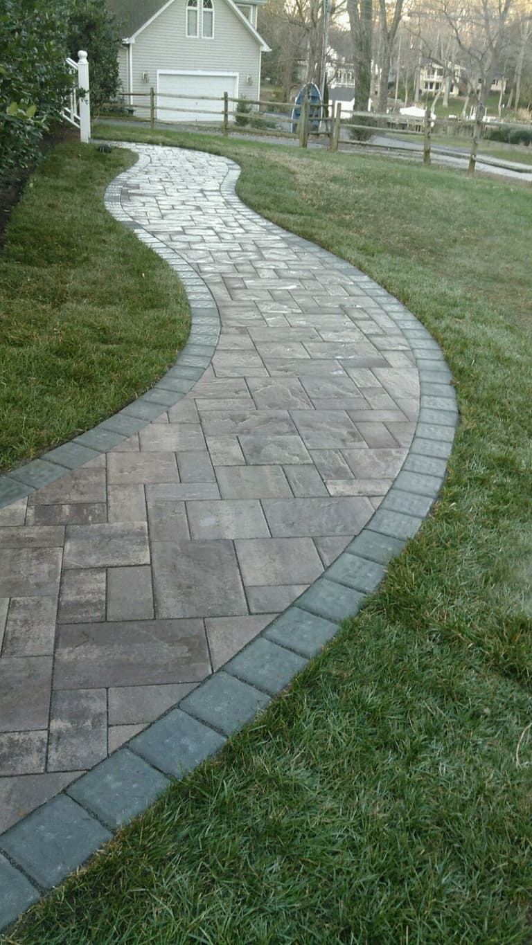 Curved paver walkway with a charcoal border sweeping across a lawn in Crownsville