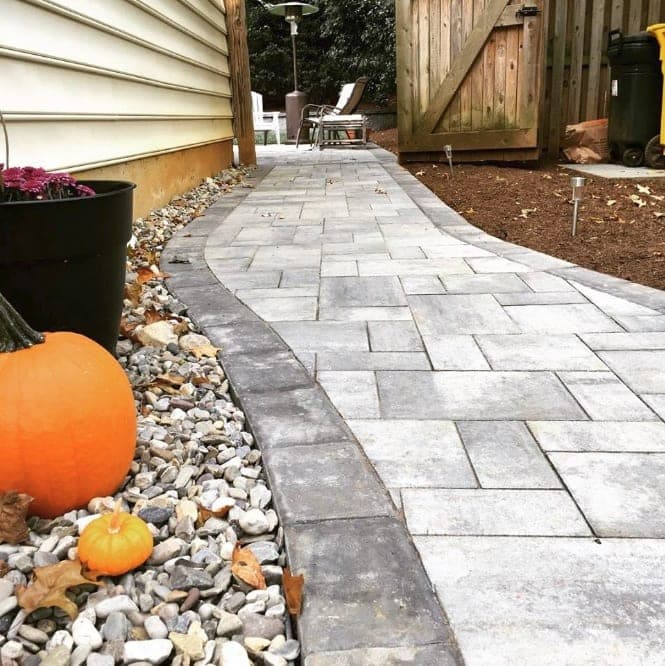 Paver walkway bordered by river rock