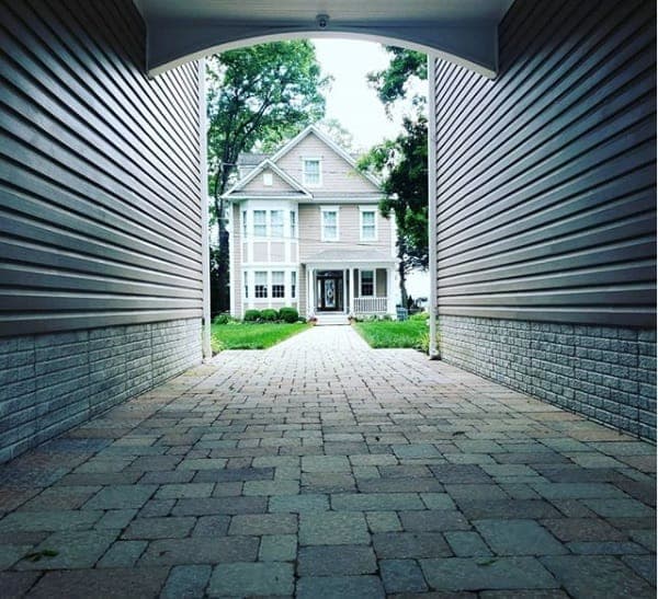 Paver walkway running between two houses to a front entry