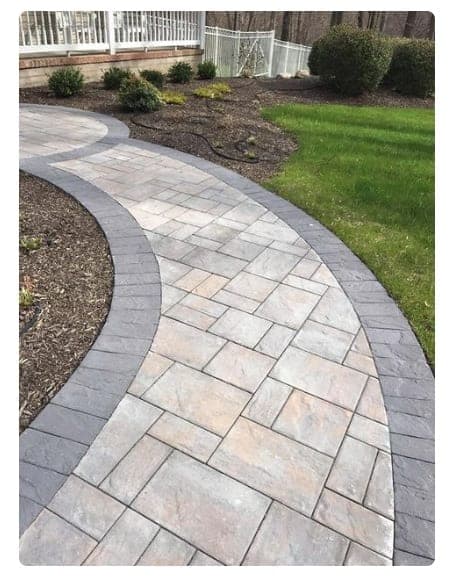 Curved paver walkway with a contrasting border through a lawn